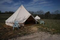 two chairs and a tent in a field at Camping Arbre de Vie in Montagnac