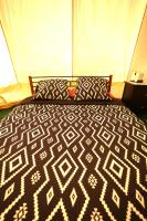 a black and white bed with pillows in a tent at Camping Arbre de Vie in Montagnac