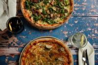 due pizze sedute sopra un tavolo di Apelviken Lägenhetshotell a Varberg