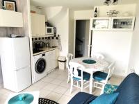 a kitchen and a living room with a table and chairs at Le Bosquito - Piscine Avril a Septembre in Saint-Hilaire-de-Talmont