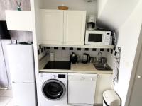 a kitchen with a washing machine and a microwave at Le Bosquito - Piscine Avril a Septembre in Saint-Hilaire-de-Talmont