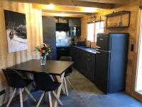 eine kleine Küche mit einem Tisch und einem Kühlschrank in der Unterkunft Chalet cosy et moderne vue montagnes in Seytroux