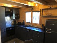 eine Küche mit schwarzen Schränken und einem Waschbecken in der Unterkunft Chalet cosy et moderne vue montagnes in Seytroux