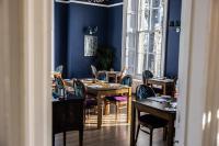 Un comedor con paredes azules y mesas y sillas. en Marshall Meadows Manor House, en Berwick-Upon-Tweed