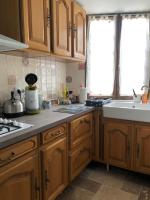 a kitchen with wooden cabinets and a sink at Charmante Maison Pierres 1768 in Polisy