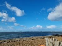 a beach with a wooden fence and the ocean at La belle Perrochoise 13 mobilhome in La Cotinière