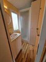 a bathroom with a sink and a mirror at La belle Perrochoise 13 mobilhome in La Cotinière