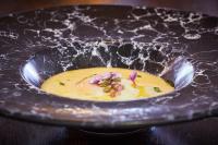 uma tigela de sopa com flores sobre uma mesa em Il Castelluccio Country Resort Restaurant & SPA em Barberino di Mugello