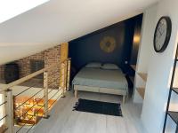 a bedroom with a bed and a clock on the wall at L&#39;ETERNEL in Longeville-lès-Metz