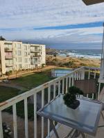 Un balcón con mesa y vista al mar. en Dpto Bordemar 2, en Las Cruces