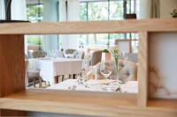 Una mesa con copas de vino y flores encima. en Hotel Rudolf, en Brunico