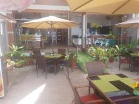 een buitenterras met tafels, stoelen en parasols bij Hayahay Resort in Panglao