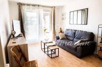 a living room with a black couch and a table at A 2 PAS du PORT in Saint-Valéry-sur-Somme