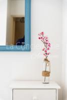 a vase with flowers on a table in front of a mirror at A 2 PAS du PORT in Saint-Valéry-sur-Somme