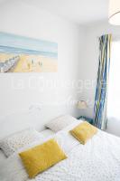 a bedroom with two beds and a painting of a beach at A 2 PAS du PORT in Saint-Valéry-sur-Somme