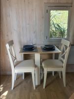 a dining room table with two chairs and a window at Adorable chalet avec jacuzzi privatif in Aix-en-Provence