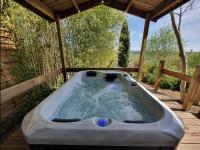 a bath tub sitting on a wooden deck at Adorable chalet avec jacuzzi privatif in Aix-en-Provence