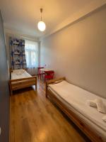 two beds in a room with a table and chairs at Orange Cat Rooms in Riga