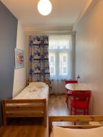 a bedroom with a bed and a table with chairs at Orange Cat Rooms in Riga