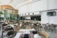 a restaurant with tables and chairs and a bar at Bayphere Hotel Pattaya JC in Na Jomtien