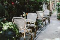 a row of chairs and a table on a sidewalk at 6號花園別墅酒店 Shenzhen No'6 Garden Villa --French Window with garden view,Close to Sea World &Shekou Ferry Port &K11 Ecoast &Subway Nearby ,Offer Western food and coffee &English speaking with tour services in Shenzhen