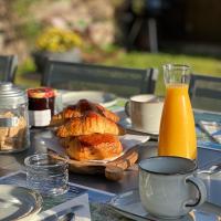 a table with a plate of pastries and a jug of orange juice at Les 5 Arches in Sisco