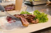 une assiette avec un morceau de viande et une salade dans l'établissement Relais Villa Olivi, à Costermano