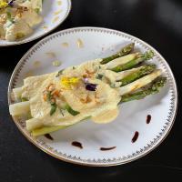 un plato de comida con espárragos en una mesa en Au Presbytère de Saigneville, en Saigneville