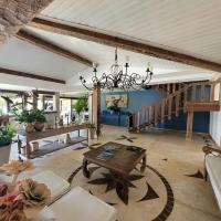a living room with a table and a chandelier at Pousada Casa do Catavento in Búzios