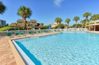 ein großer Swimmingpool mit Stühlen und Palmen in der Unterkunft Beachy Keen in Destin