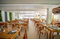 a dining room with wooden tables and chairs at Coral Costa Caribe Beach Resort - All Inclusive in Juan Dolio