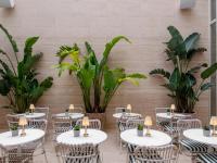 una habitación con mesas, sillas y plantas en Browns Avenue Hotel, en Lisboa
