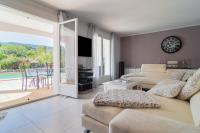 a living room with a couch and a sliding glass door at Les Vergers in Gonfaron