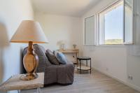 a living room with a couch and a lamp on a table at Les Vergers in Gonfaron