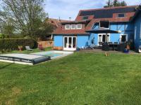 una casa con piscina en un patio en La maison bleue, en Altenbach