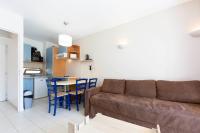 a living room with a couch and a table and a kitchen at 1 bedroom apartment in a residence with a swimming pool and a parking spot in Vallauris