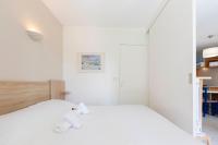 a white bedroom with a bed and a mirror at 1 bedroom apartment in a residence with a swimming pool and a parking spot in Vallauris