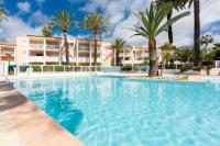 a large swimming pool with palm trees and buildings at 1 bedroom apartment in a residence with a swimming pool and a parking spot in Vallauris
