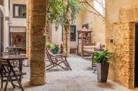 a courtyard with tables and chairs in a building at Hotel Boutique V in Vejer de la Frontera