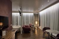 Una sala de estar con un sofá, una mesa y sillas. en Hótel Vesturland, en Borgarnes