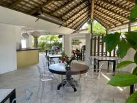 Un comedor con mesas y sillas y un techo en Cosy Guest House Sous le Badamier, en Grand Baie