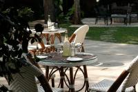 库斯哈尔纳加尔库格阿曼瓦纳spa度假村的一张户外桌椅和两瓶香槟