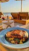 a plate of food with fish and vegetables on a table at Wala Hotel and Beach Club in Cartagena de Indias