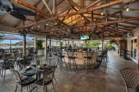 a restaurant with tables and chairs and a bar at Bayfront Inn 5th Avenue in Naples