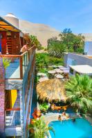 a resort with a pool with umbrellas and a resort at Banana&#39;s Adventure Hostel in Ica