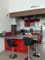 a kitchen with red cabinets and black bar stools at Le jardin de l&#39;horloge in La Rochelle