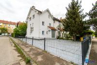 a white house behind a fence at MODERN apartments WAVE near the AIRPORT in Velika Gorica