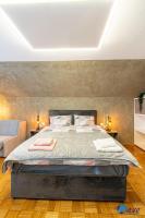 a bedroom with a large bed with a stone wall at MODERN apartments WAVE near the AIRPORT in Velika Gorica