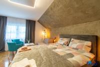 a bedroom with a large bed and a blue chair at MODERN apartments WAVE near the AIRPORT in Velika Gorica