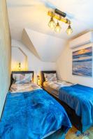 two beds in a room with blue sheets at MODERN apartments WAVE near the AIRPORT in Velika Gorica